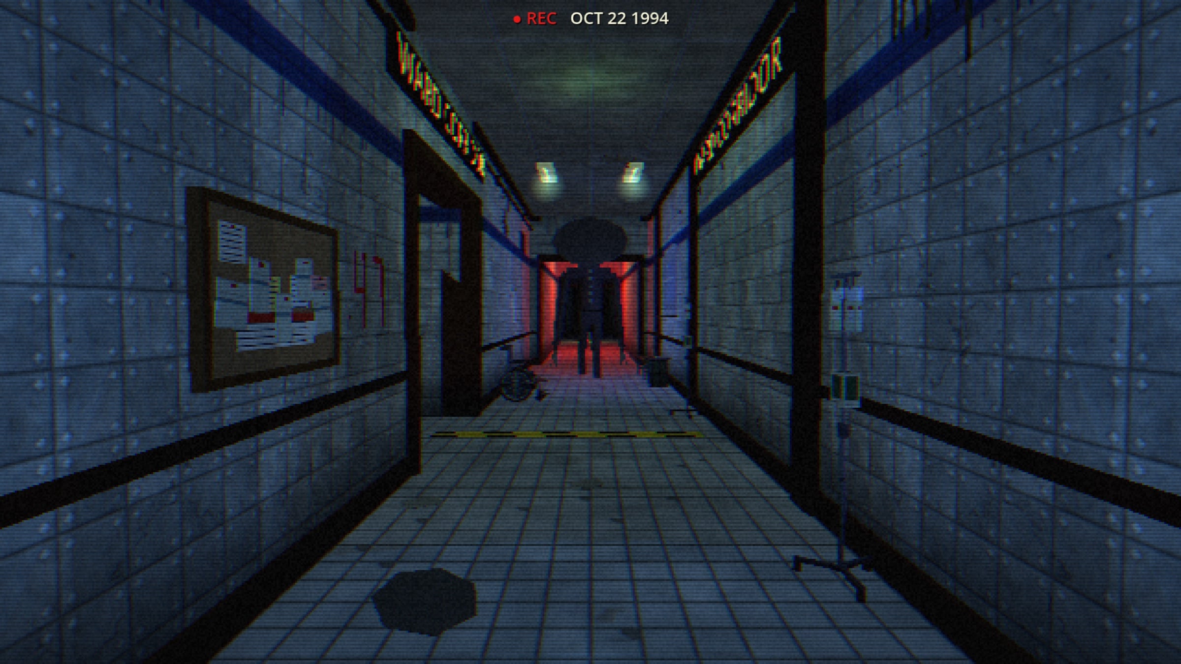 A tiled hospital corridor on a camcorder recording, a tall silhouette standing in a red-lit doorway at the far end.